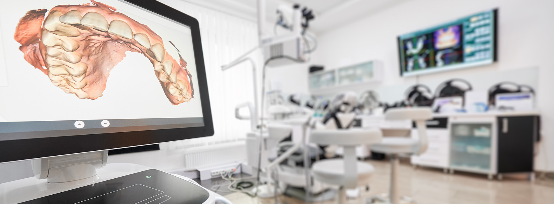 The image depicts a modern dental office with a large screen displaying an animated 3D model of a mouth, likely used for educational or diagnostic purposes.