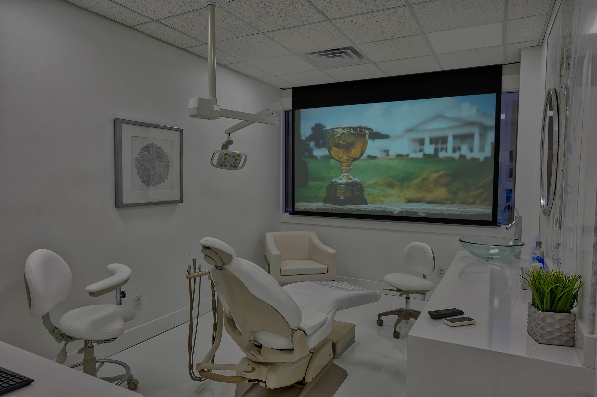 An interior view of a dental office with a large screen displaying an outdoor scene.