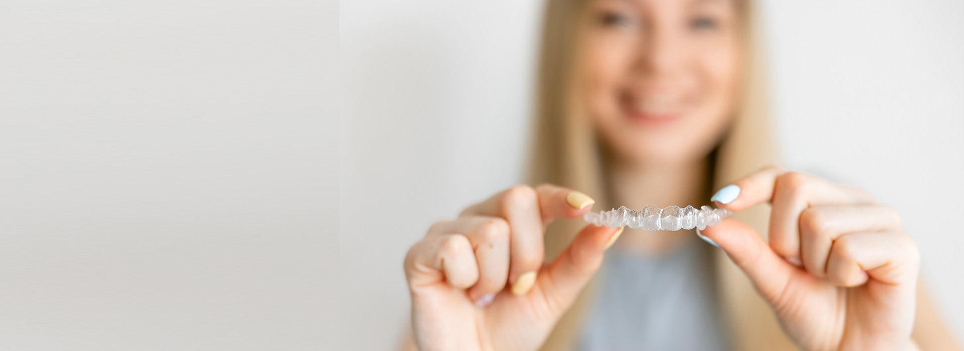 Woman holding jewelry with a smile, showcasing her hand-picked collection.