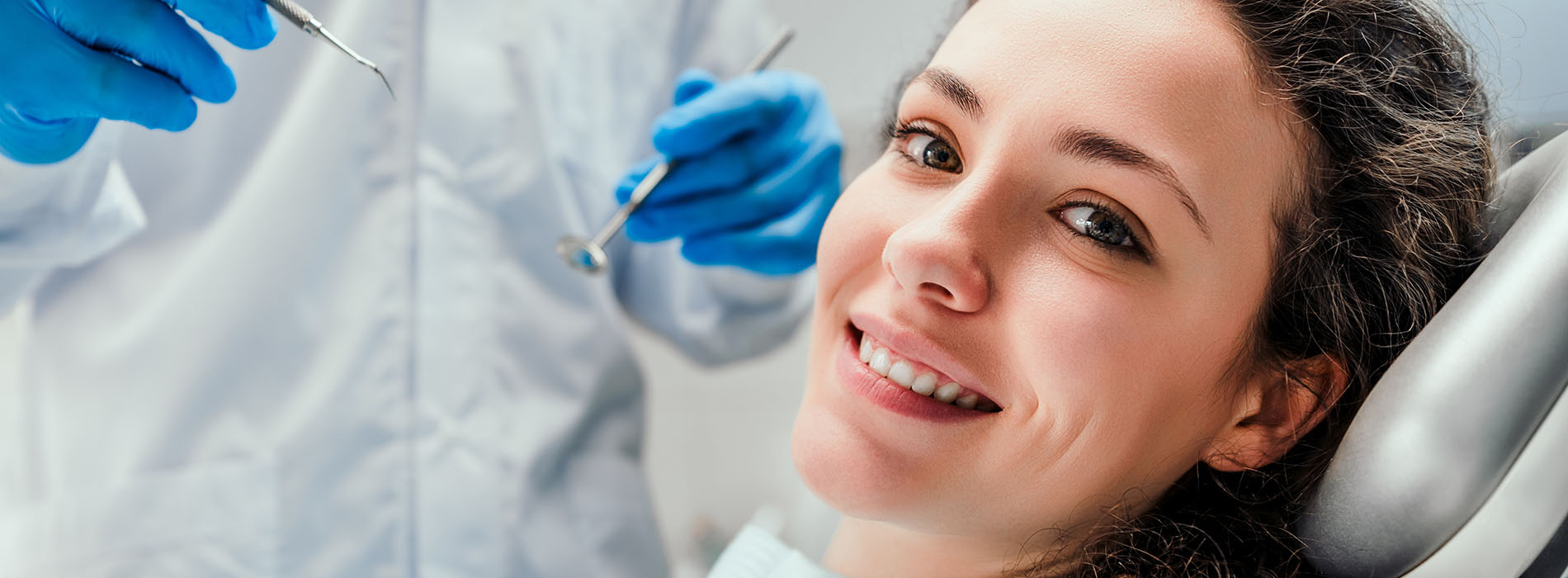A young woman receiving dental care with a dentist performing a procedure.