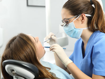 Woman receiving dental treatment from professional, with focus on oral hygiene and care.